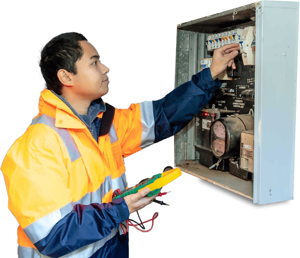 Local electrician in safety gear holding a multimeter, inspecting a white switchboard for a switchboard upgrade.